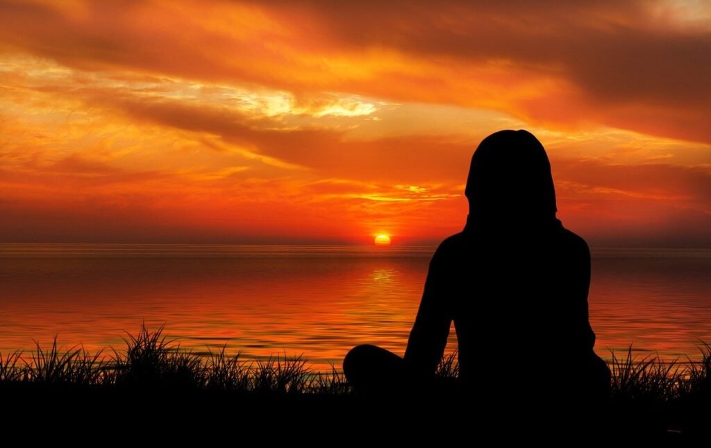 A girl’s back against sunset as if she was in deep thinking 