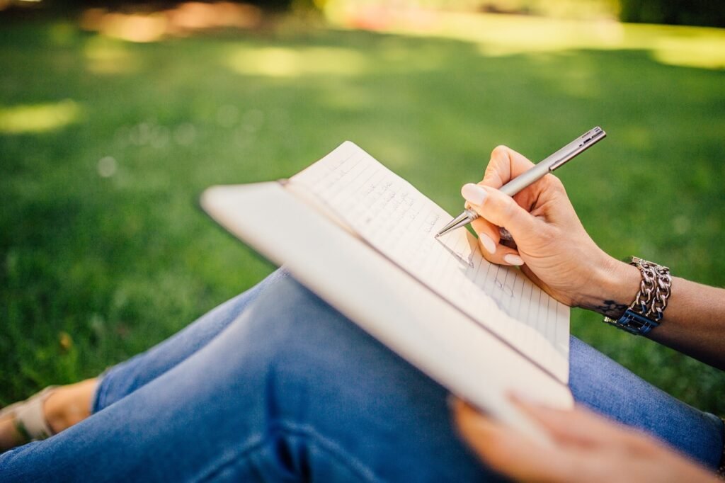 The writing image of a girl’s hand sitting on the lawn